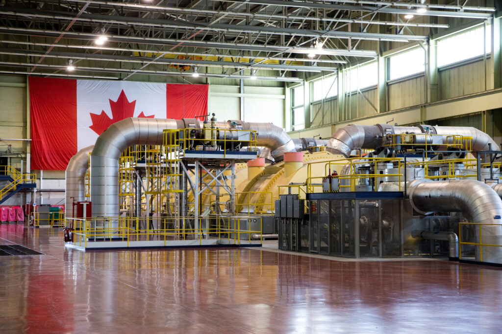 Nuclear reactor inside opperating floor. Canadian flag behind it hanging on a wall.